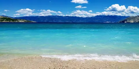 Piękna, błękitna woda i kamienista plaża. Idealne miejsce, by sprawdzić, gdzie najcieplej w czerwcu i cieszyć się słońcem.