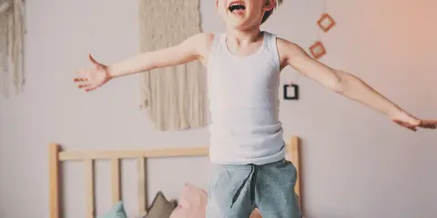 Bambino iperattivo 4 anni cosa fare? Un bimbo salta sul letto, pieno di energia.