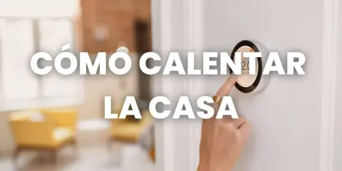 A mano ajusta un termostato inteligente, mostrando cómo calentar una casa económicamente.