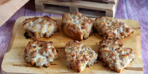 Sei crostini salsiccia e stracchino dorati e filanti, pronti per essere gustati.