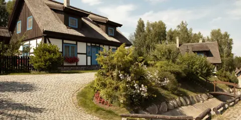 Urokliwe dwory i pałace na Kaszubach, z charakterystycznymi strzechami i niebieskimi okiennicami, otoczone zielenią i brukowanymi alejkami.