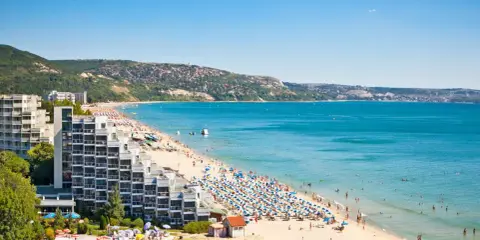 Słoneczny złoty brzeg Bułgaria tętni życiem. Tłumy plażowiczów, hotele i turkusowe morze tworzą wakacyjny krajobraz.