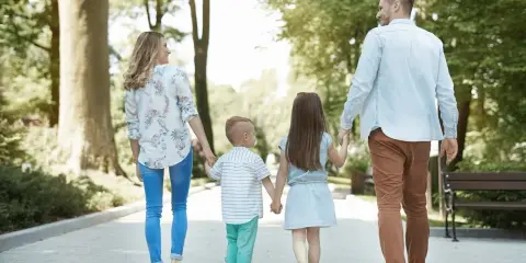 Familia paseando por un parque, ideal para saber qué hacer en León con niños y disfrutar del aire libre.