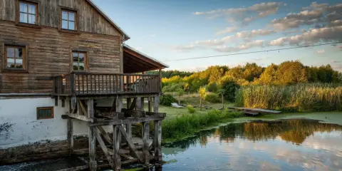 Drewniany młyn nad wodą, otoczony zielenią. Idealne miejsce na weekendowe wypady, szukając fajne miejsca niedaleko Warszawy na weekend.