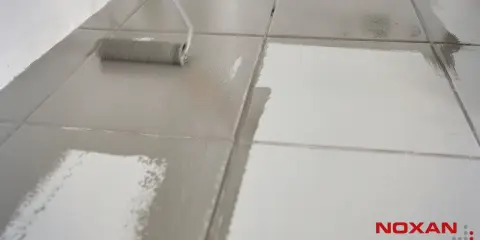 Wałek maluje podłogę z płytek, nadając jej matowe wykończenie. Dowiedz się, jak zmatowić płytki.