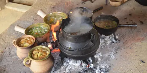 Ein mittelalterliches Festmahl: Eintöpfe und Suppen köcheln über offenem Feuer. Essen und trinken im Mittelalter war oft eine Gemeinschaftsangelegenheit.