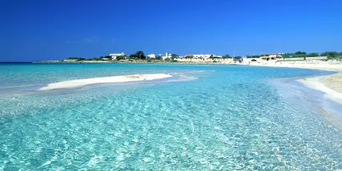 Acque cristalline e sabbia bianca a Punta Prosciutto, uno dei lidi migliori del Salento.