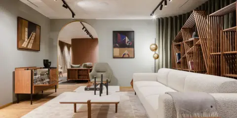 Salon moderne avec canapé blanc texturé, table basse en marbre et bois, et étagère design. Une parfaite illustration de la tendance déco actuelle.
