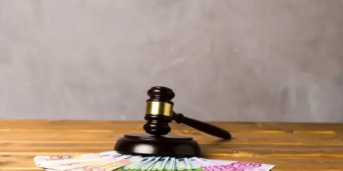 Młotek sędziowski na euro symbolizuje alimenty ojca w Polsce, gdy dziecko mieszka za granicą.