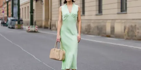 Elegancka zielona sukienka z beżową torebką i brązowymi balerinkami – idealne dodatki do zielonej sukienki na miejski spacer.
