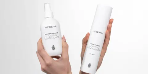 Zwei NEWSHA Leave-In Conditioner Flaschen in Händen. Für eine tiefenreinigung haare und Stärkung.