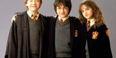 Harry, Ron und Hermine, die berühmten Namen aus Harry Potter, in ihren Gryffindor-Umhängen.