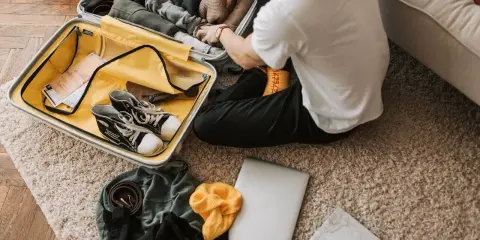 Pakowanie walizki: ubrania, buty, laptop, mapa. Zastanawiasz się, co zabrać na wakacje? Oto inspiracja!