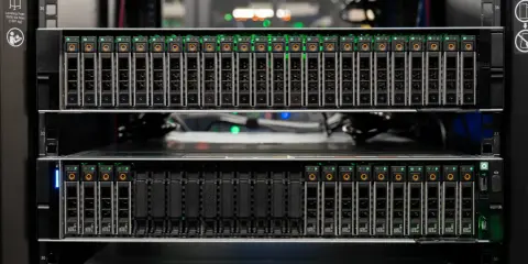 Serveur avec plusieurs baies de disques SSD, toutes allumées en **full flash**. Les indicateurs verts brillent intensément.