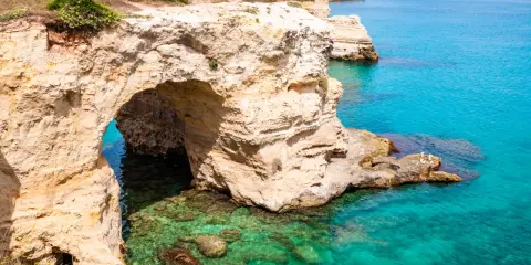 Scogliere dorate e mare cristallino, un'incantevole grotta marina. Perfetto per un Ferragosto Salento indimenticabile.