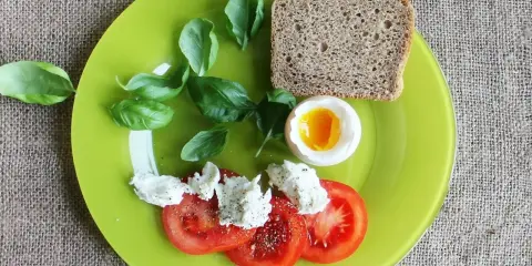 Śniadanie: jajko na miękko, pomidory z mozzarellą, chleb. Idealne, gdy zastanawiasz się, ile gotować jajka na miękko.