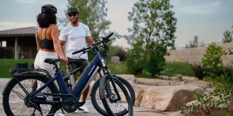 Para zwiedzająca park na nowoczesnych rowerach elektrycznych. To rower przyszłości, który ułatwia podróżowanie.