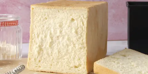 Un pain de mie parfait, tout juste sorti du four. La cuisson du pain de mie est une étape clé pour obtenir cette mie aérée et cette croûte dorée.