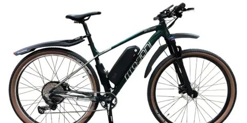 Zielony rower z napędem elektrycznym, zestaw do konwersji roweru 250w. Wyposażony w błotniki i opony z brązowymi bokami.