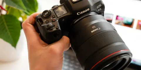 Dłoń trzyma aparat Canon R5 z obiektywem 50mm. Trwa test możliwości sprzętu.