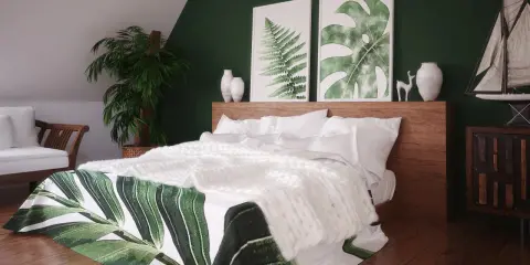 Przytulna sypialnia boho zielona z roślinnymi motywami na pościeli, białym pledem i drewnianymi meblami.