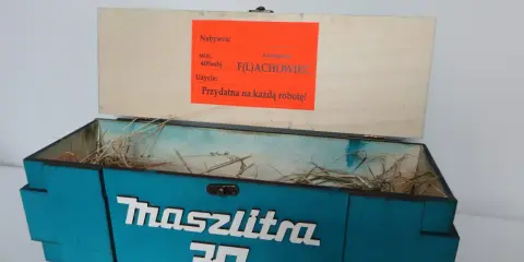Otwarta, turkusowa skrzynka na 30 urodziny z napisem "Maszlitra 30". W środku sianko. Na wieczku etykieta "Najlepszy F(L)ACHOWIEC".