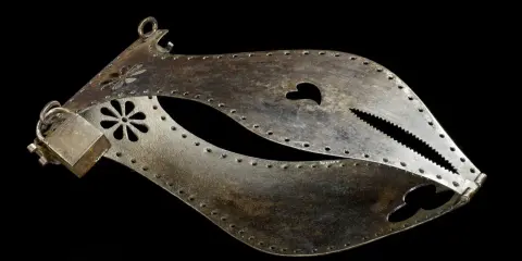 Metalowy pas cnoty, ozdobiony kwiatami i sercem, z ząbkowanym zamknięciem.