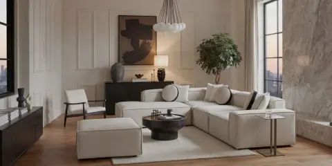 Un soggiorno con un divano componibile bianco, tavolino nero, poltrona e pouf. L'arredamento riflette uno stile contemporaneo casa, con un quadro astratto e una lampada di design.