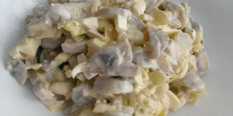 Pyszna sałatka pieczarkowa z porem i jajkiem, polana kremowym sosem. Idealna na każdą okazję.