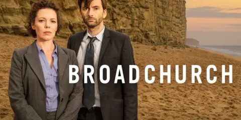 Två poliser står på en strand framför en klippa. Serien Broadchurch är en av de bästa kriminalserier topplista.