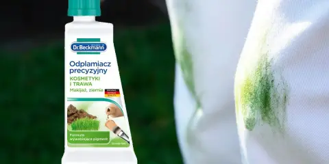 Butelka odplamiacza Dr. Beckmann na białej tkaninie z zieloną plamą.