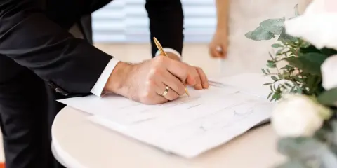 Novio firma documentos. Esto es parte de lo que se necesita para casarse por lo civil.