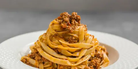 Porcja tagliatelle z bogatym sosem mięsnym, klasyczne spaghetti bolognese w nowej odsłonie.