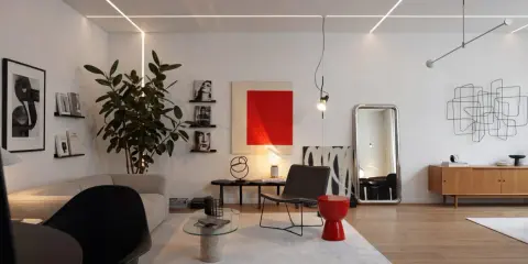 Salotto moderno con divano, poltrona, tavolino in vetro e un tocco di stile bauhaus nell'arredamento.