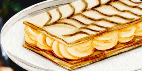 Un délicieux gâteau sec français traditionnel, un mille-feuille aux couches croustillantes et à la crème onctueuse, décoré de volutes de chocolat.