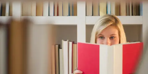 Blondynka z książką w rękach, ukryta za nią, jakby przekraczała granicę zofia nałkowska.