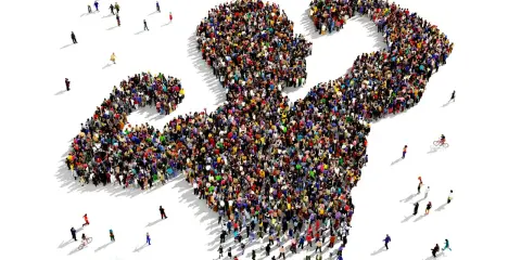 Een grote groep mensen vormt de gestalte van een gespierde arm, wat de kracht van de massa symboliseert. Dit beeld roept vragen op over wat is populisme en hoe de massa wordt gemobiliseerd.