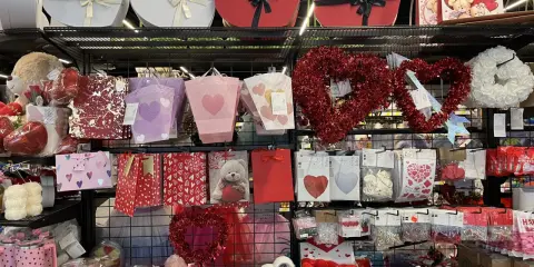 Półki sklepowe z prezentami walentynkowymi: serca, misie, torebki, ozdoby.