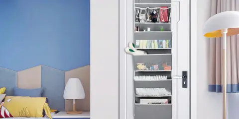 Grauer **Pocket Schrank** an der Tür mit vielen Fächern, gefüllt mit Kosmetik, Spielzeug und Windeln.