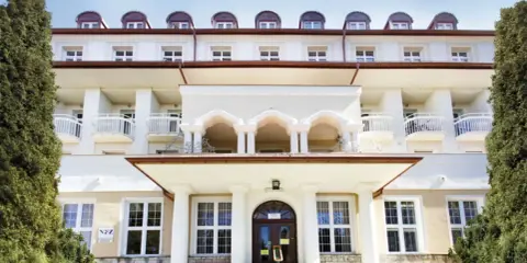 Sanatorium Jadwiga w Lądku Zdroju, z charakterystycznymi arkadami i balkonami, zaprasza na wypoczynek.