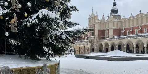 Świąteczna choinka na Rynku Głównym w Krakowie, otoczona śniegiem. To jedna z głównych kraków atrakcje zimą.