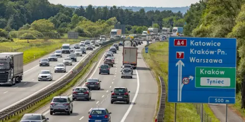 Korek na autostradzie A4 w kierunku Katowic. Samochody stoją w długim sznurze, a znaki drogowe wskazują drogę do Krakowa i Tynca.