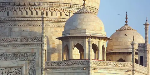 Detailansicht des Taj Mahal, ein Meisterwerk islamischer Architektur mit kunstvollen Verzierungen und Kuppeln.