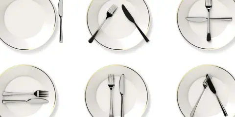 Six assiettes blanches avec des couverts disposés de différentes manières, illustrant la position des couverts signification.