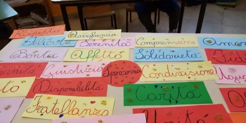 Lavoretti per open day scuola primaria: cartelloni con parole positive come "Rispetto", "Felicità", "Amicizia", "Solidarietà", "Carità", "Unità".