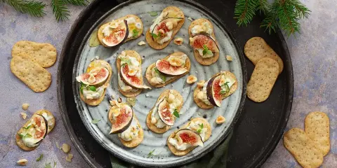 Smakliga snittar med fikon, ost och nötter på kex. Ett perfekt recept för festen!