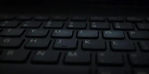 Klawiatura laptopa, gotowa do pisania głosowego w Word. Litery T, Y, U, I, O, P, G, H, J, K, L, B, N, M widoczne.
