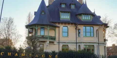 La villa Demoiselle Pommery, une demeure Belle Époque aux toits d'ardoise et aux ornements verts, se dresse fièrement.