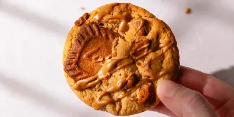 Un biscuit au speculoos, généreusement garni de morceaux et nappé d'une sauce caramel.