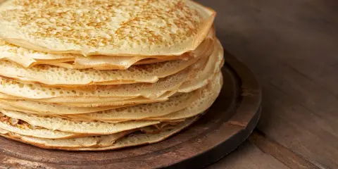 En hög med gyllene pannkakor, redo att serveras. Perfekt för ett enkelt pannkakor recept.